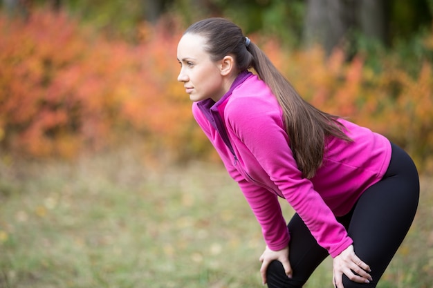 Mujer calentando al aire libre en el otoño,