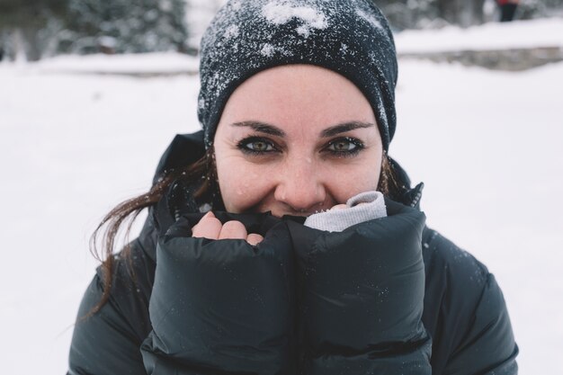 Mujer calentando las manos sobre fondo nevado