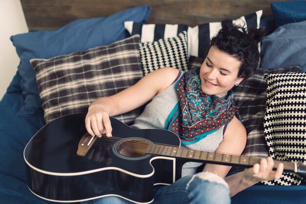 Mujer en cama con guitarra