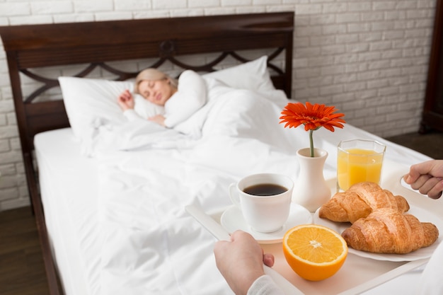 Foto gratuita mujer en la cama sorprendida con flores y desayuno