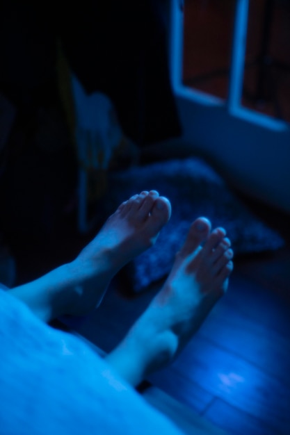 Mujer en la cama en su casa con luces misteriosas a su alrededor