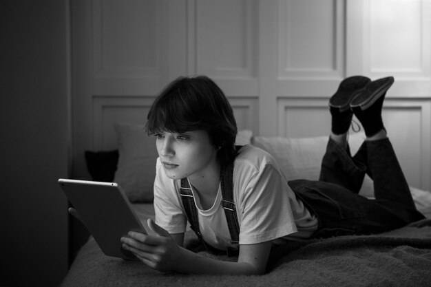 Mujer en la cama con tablet full shot