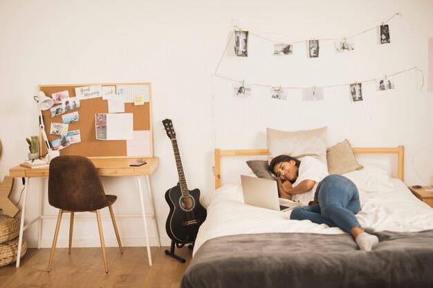 Mujer en la cama trabajando en la computadora portátil