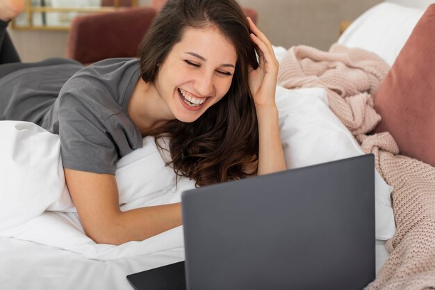 Mujer, en cama, usar la computadora portátil