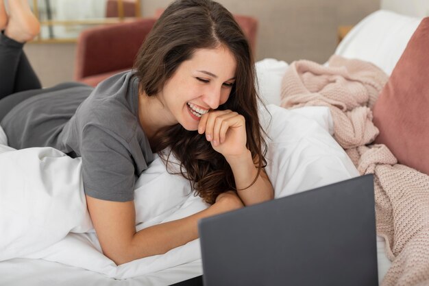 Mujer, en cama, usar la computadora portátil