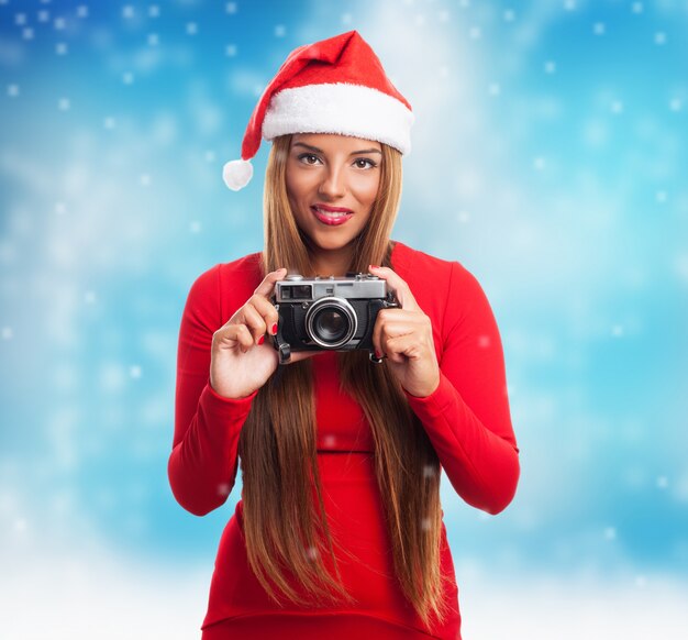 Mujer con un cámara antigua mientras nieva