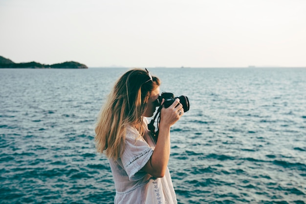 Foto gratuita mujer, con, cámara, disparar, en la playa