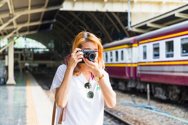 Mujer, con, cámara, en, estación del ferrocarril