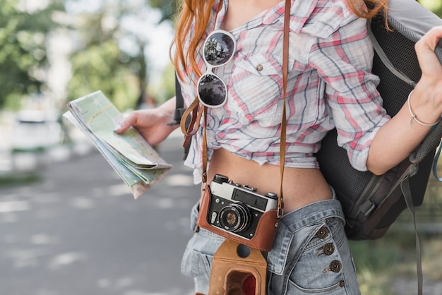 Foto gratuita mujer con cámara vintage y mapa