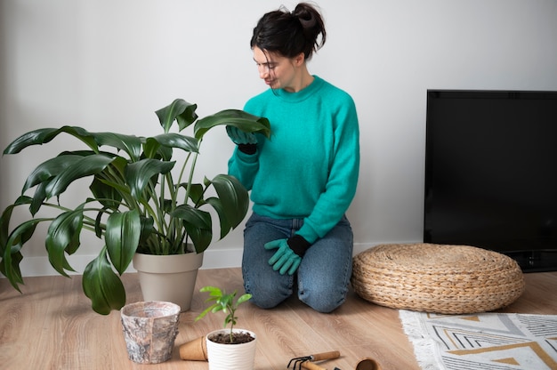 Mujer cambiando las macetas de sus plantas en casa durante la cuarentena
