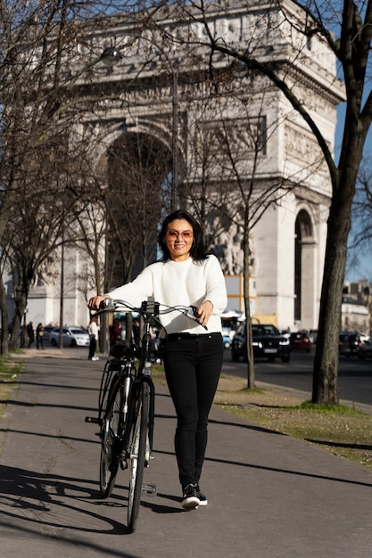 Mujer caminando con una bicicleta en la ciudad de francia