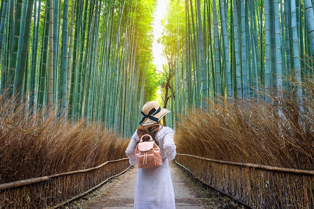 Mujer caminando en el bosque de bambú en Kyoto, Japón.