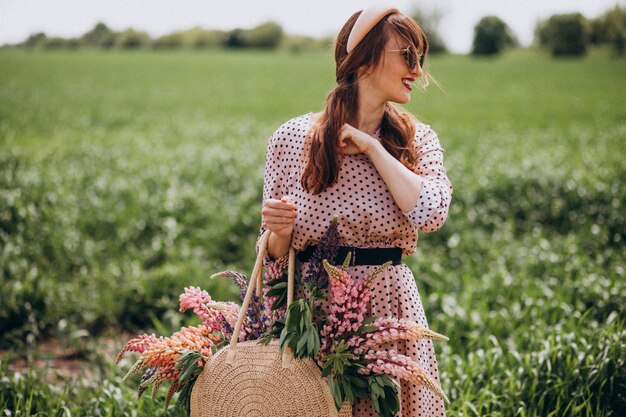 Mujer caminando en un campo con lupinos