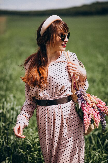 Mujer caminando en un campo con lupinos