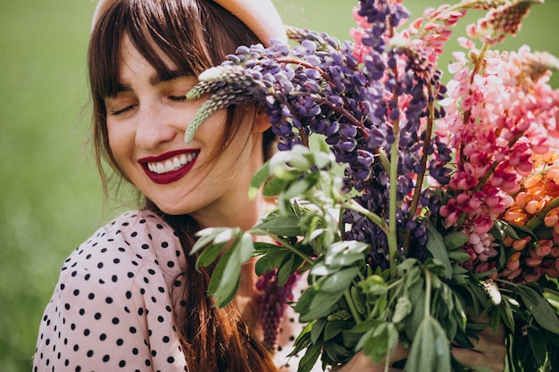 Mujer caminando en un campo con lupinos