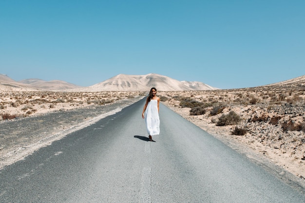 Mujer caminando por la carretera en las tierras altas