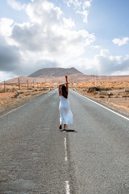 Mujer caminando por la carretera en las tierras altas