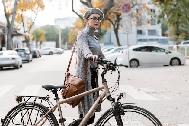 Foto gratuita mujer caminando junto a su bicicleta