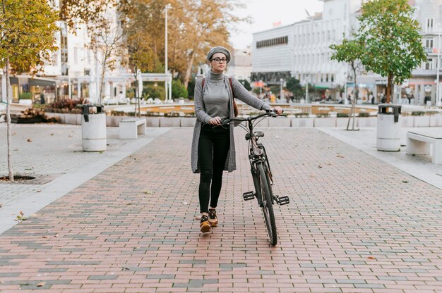 Mujer caminando junto a su bicicleta