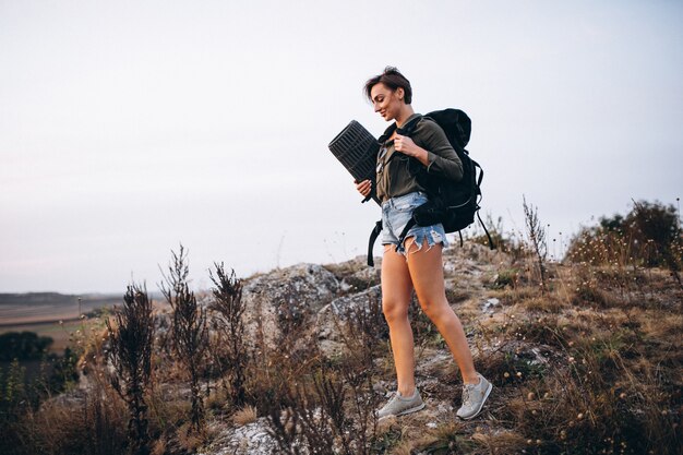 Mujer caminando en las montañas con bolsa de viaje