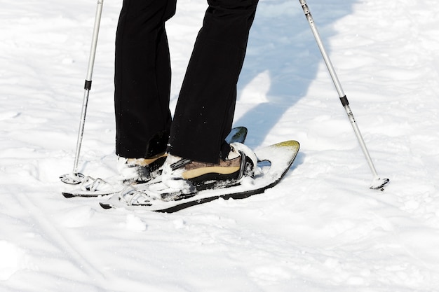 Foto gratuita mujer caminando en la nieve con raquetas