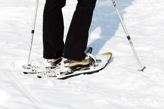 Mujer caminando en la nieve con raquetas