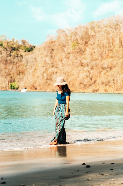 Mujer caminando por la orilla del mar