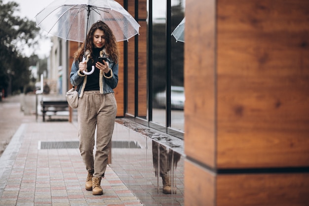 Mujer caminando bajo el paraguas en un clima lluvioso