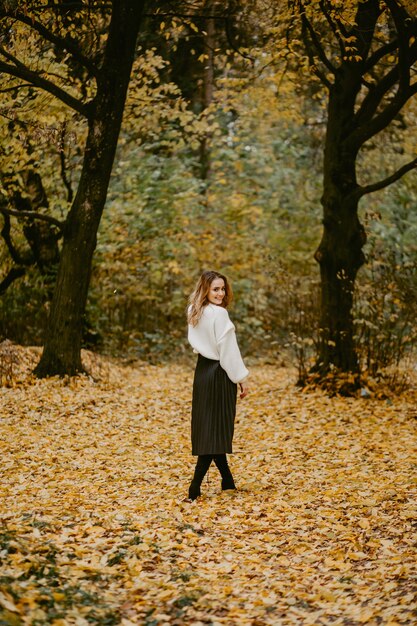 Mujer caminando en el parque otoño