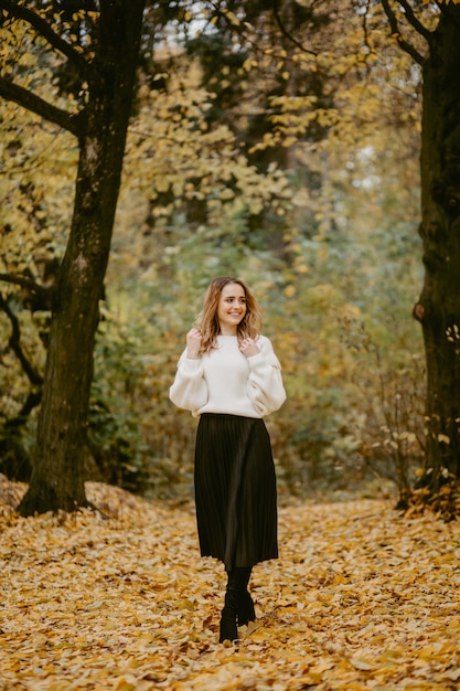 Mujer caminando en el parque otoño