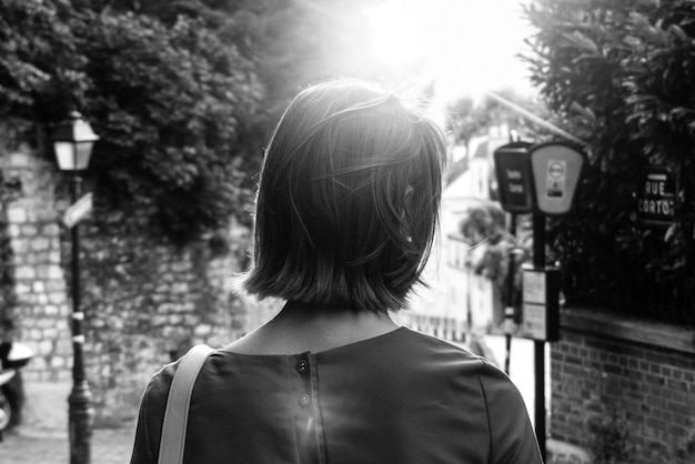 Mujer caminando hacia el poste de luz de la calle