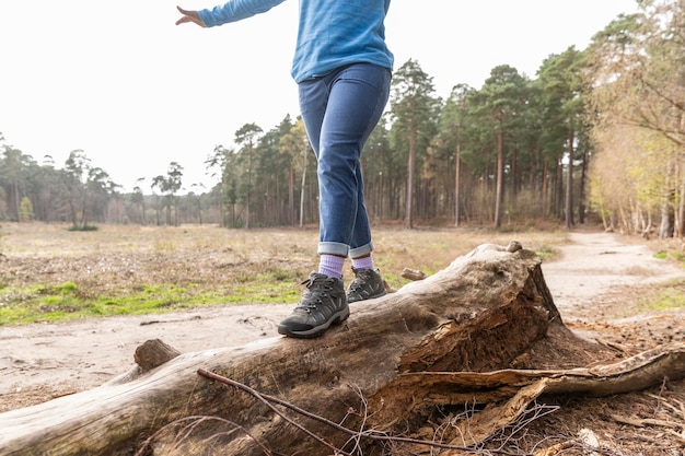 Mujer caminando sobre un árbol caído