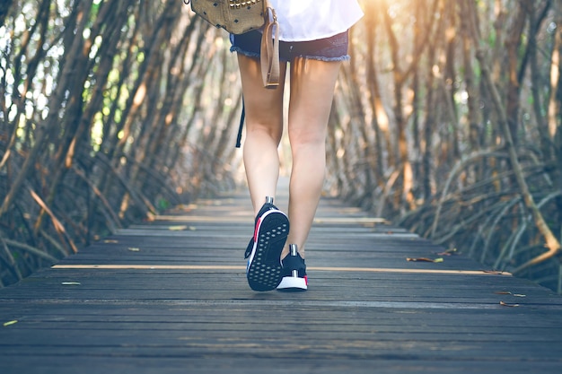 Mujer caminando sobre un puente de madera. Tono vintage.