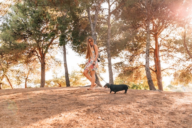 Mujer caminando con su perro en el jardín