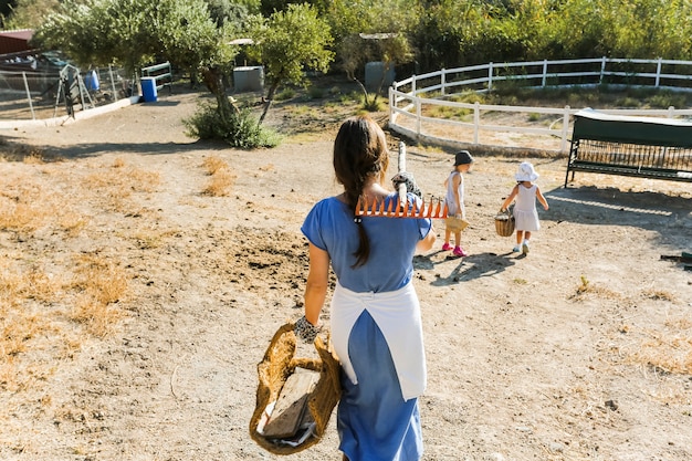 Mujer caminando con sus hijas en el campo