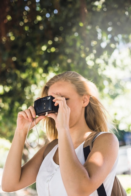 Mujer caminante fotografiando con tableta digital al aire libre