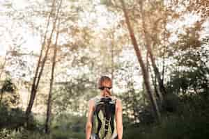 Foto gratuita mujer caminante de pie en el bosque verde