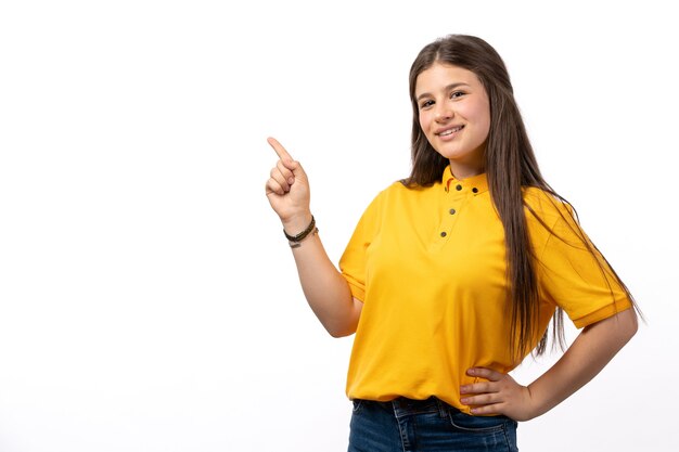 mujer en camisa amarilla y pantalones vaqueros azules posando con expresión feliz en el fondo blanco ropa modelo mujer