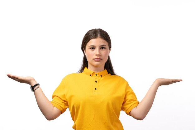 mujer en camisa amarilla y pantalones vaqueros azules posando con las palmas abiertas sobre el fondo blanco ropa modelo mujer