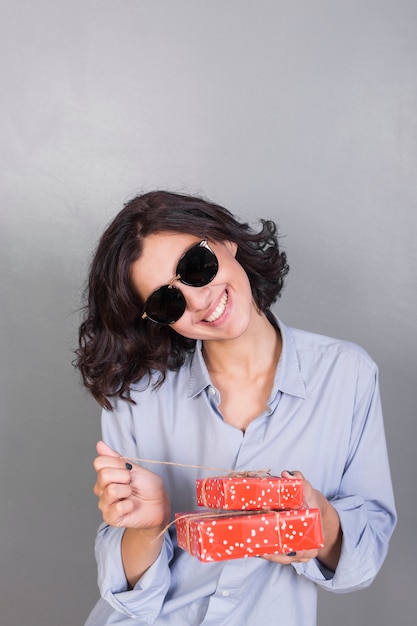 Mujer en camisa azul con caja de regalo