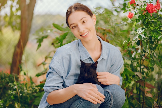 mujer en una camisa azul jugando con lindo gatito