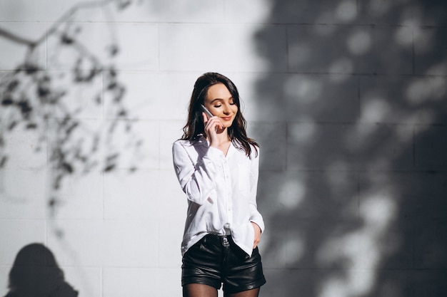 Foto gratuita mujer en camisa blanca hablando por teléfono