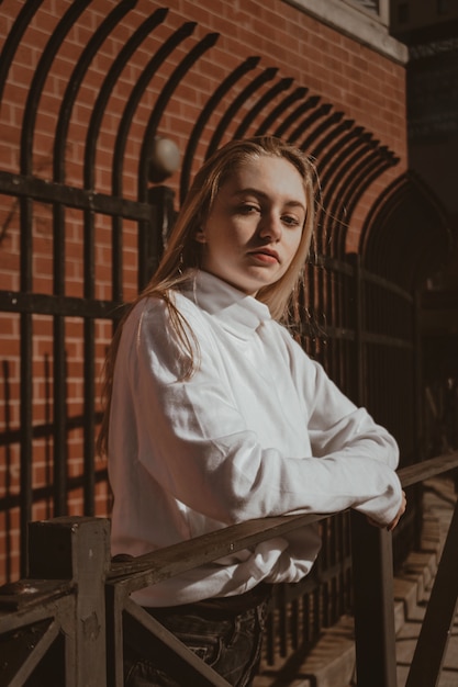 Mujer con camisa blanca en la valla de madera