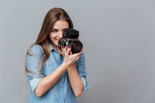 Mujer en camisa con cámara de video retro