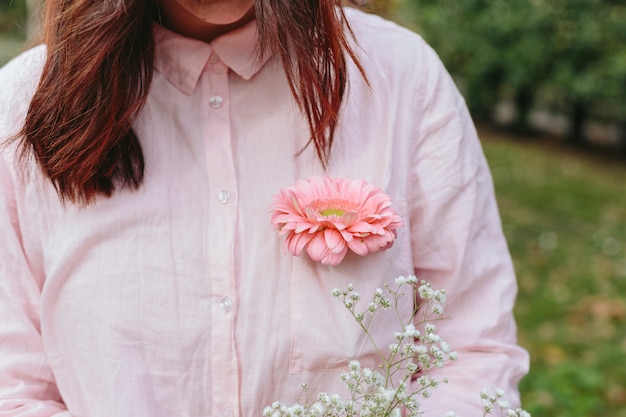 Mujer en camisa con flor en el bolsillo