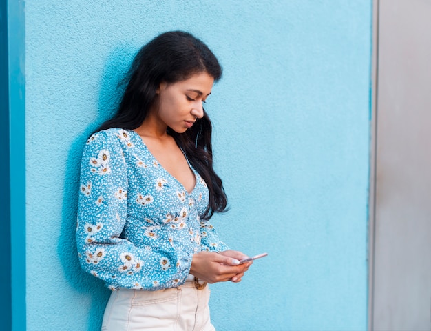 Mujer con camisa floral trabajando en su teléfono