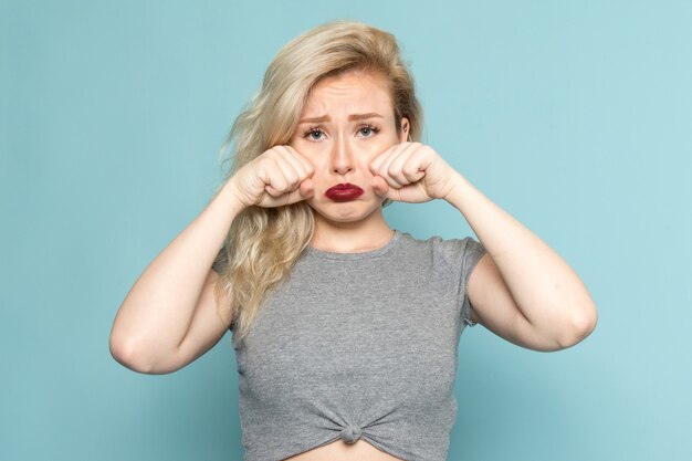 Foto gratuita mujer en camisa gris y jeans azul brillante falso llanto