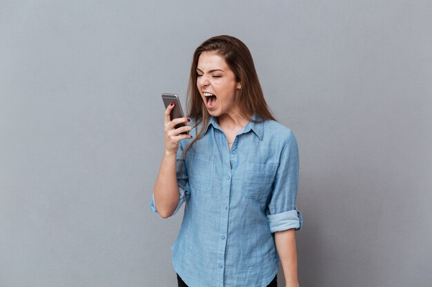 Mujer en camisa gritando por teléfono