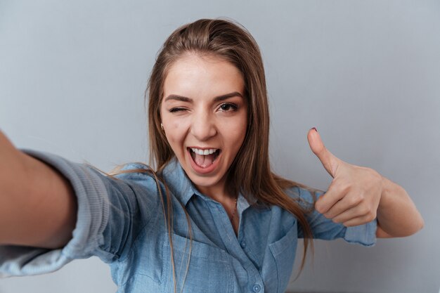 Mujer en camisa haciendo selfie en estudio