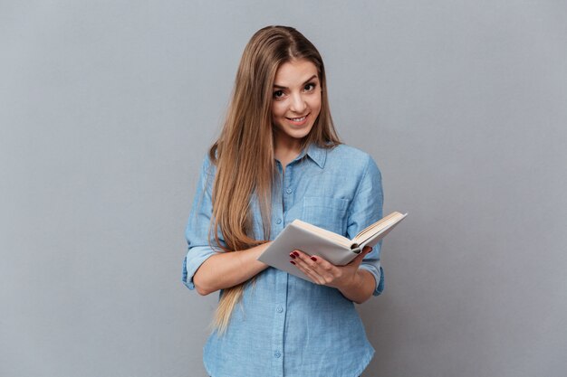 Mujer en camisa leyendo libro